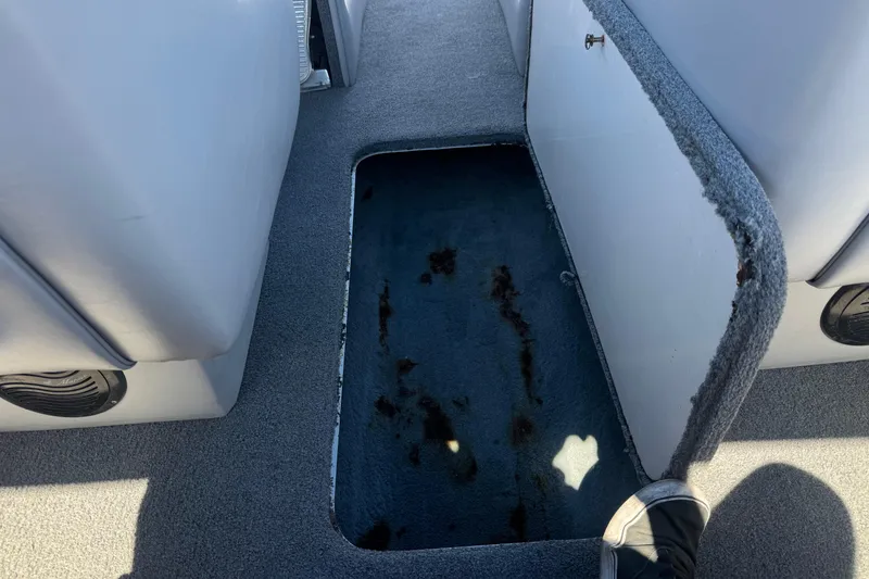 Slide: The Image of Open storage compartment in 2007 Commander 2300LX boat interior, showing carpeted floor. - 18