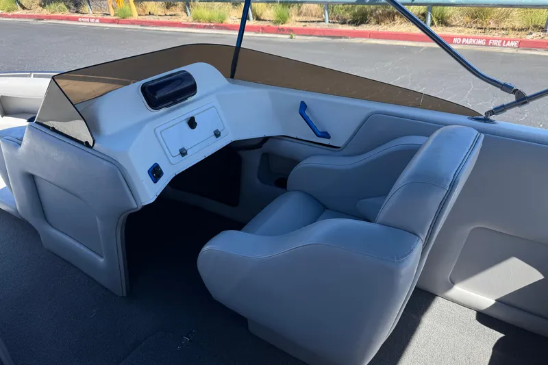 Slide: The Image of Interior of a 2007 Commander 2300LX boat, featuring gray seating and dashboard. - 19