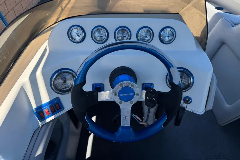 Slide: The Image of Dashboard of a 2007 Commander 2300LX boat with gauges and steering wheel. - 22