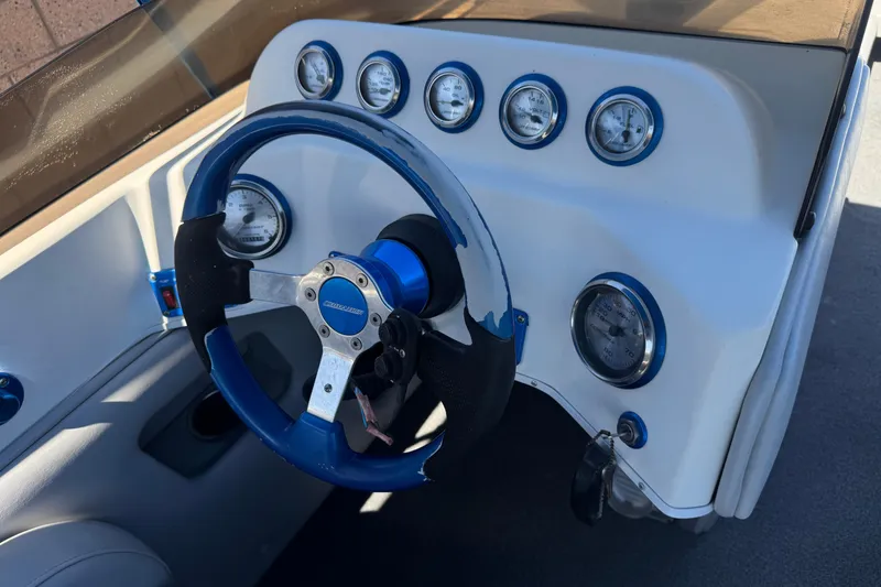 Slide: The Image of Steering wheel and dashboard of a 2007 Commander 2300LX boat with gauges. - 23