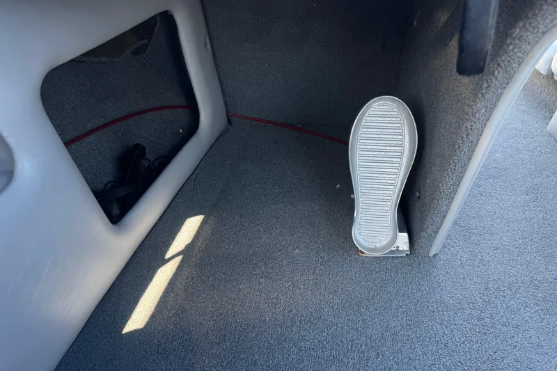 Slide: The Image of Interior of a 2007 Commander 2300LX boat showing foot pedal and carpeted flooring. - 24