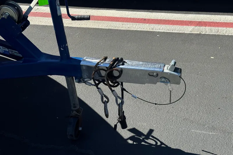Slide: The Image of Trailer hitch of a 2007 Commander 2300LX boat trailer on asphalt surface. - 26