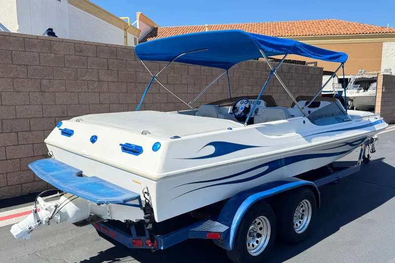 Slide: The Image of 2007 Commander 2300LX boat with blue canopy on trailer, parked outdoors. - 5