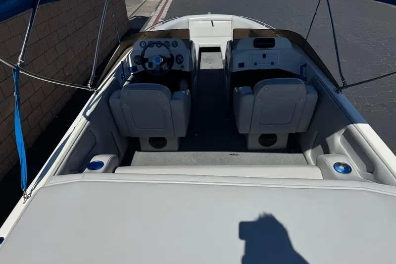 Slide: The Image of 2007 Commander 2300LX boat interior with dual seats and steering wheel, under blue canopy. - 7