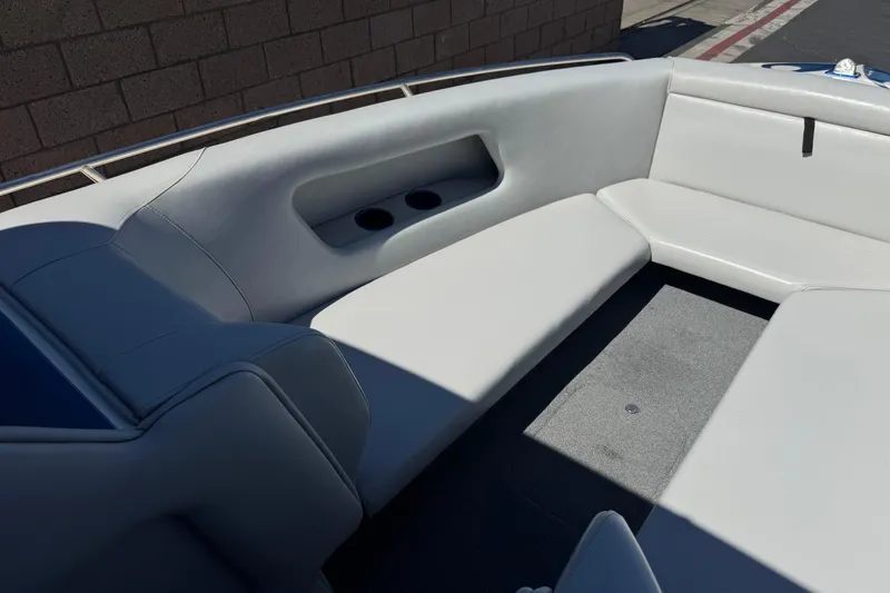 Slide: The Image of Interior seating of a 2007 Commander 2300LX boat, featuring white upholstery and cup holders. - 9