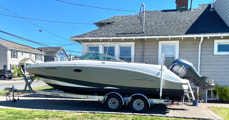 The Image of 2016 NauticStar Sport Deck 243DC on trailer in front of house. - 0