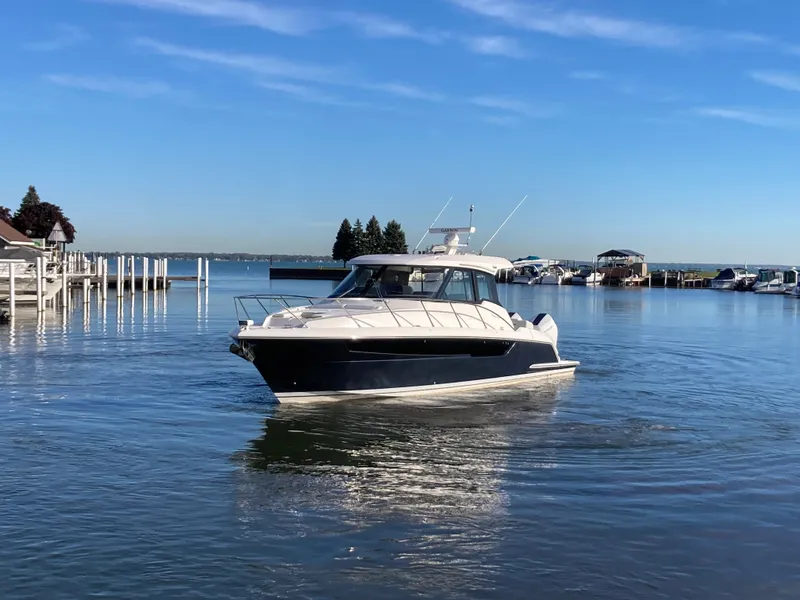 Slide: The Image of Tiara Yachts 39LE 2027 on calm water, surrounded by a harbor with boats and docks. - 48