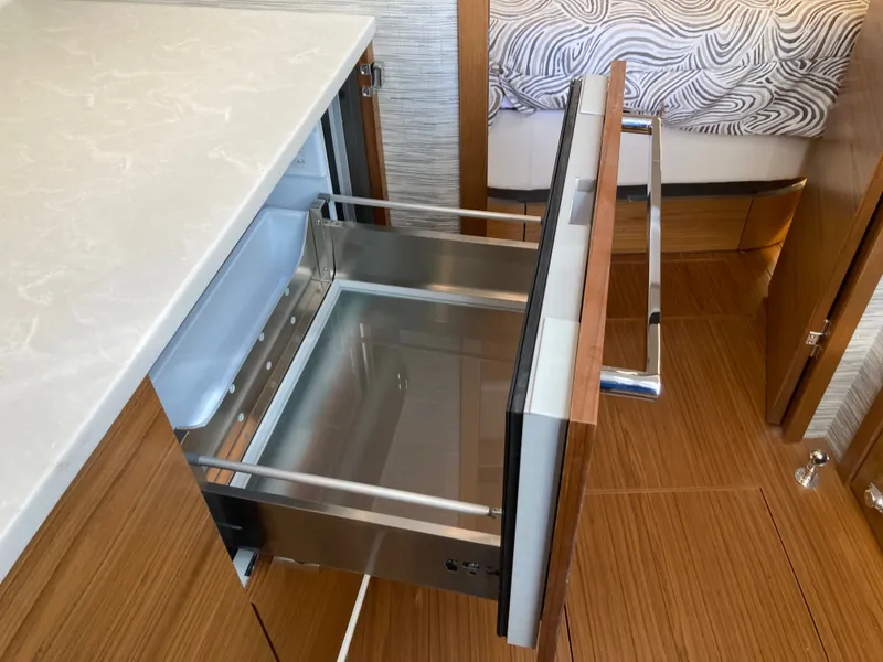Slide: The Image of A modern kitchen drawer in a yacht with wood paneling and sleek design. - 34