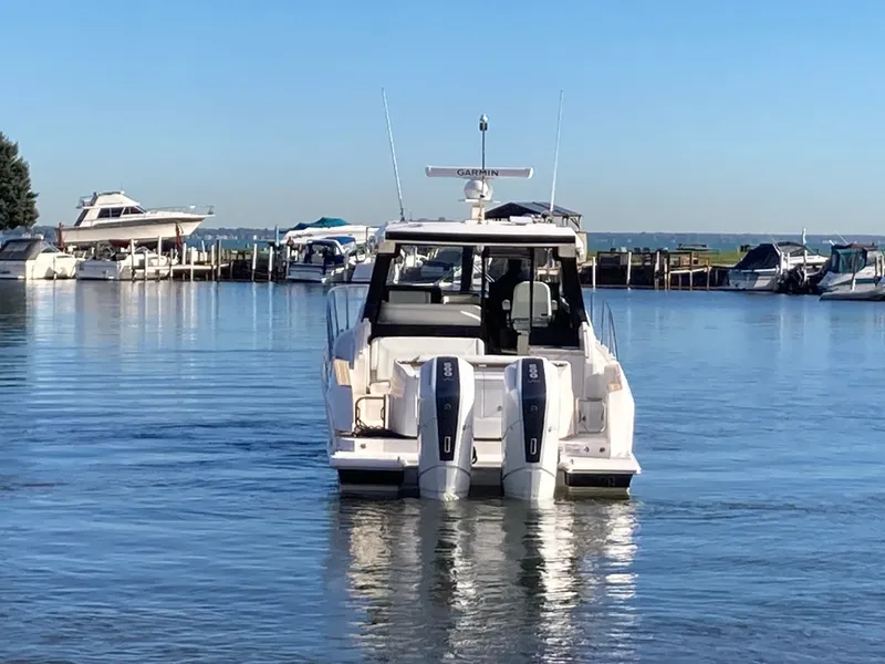 Slide: The Image of 2027 Tiara Yachts 39LE on the water, featuring twin outboard engines, in a marina. - 52