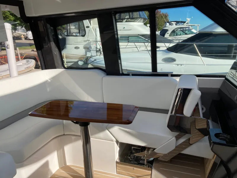 Slide: The Image of Interior of a 2027 Tiara Yachts 39LE with white upholstery and a wooden table. - 15