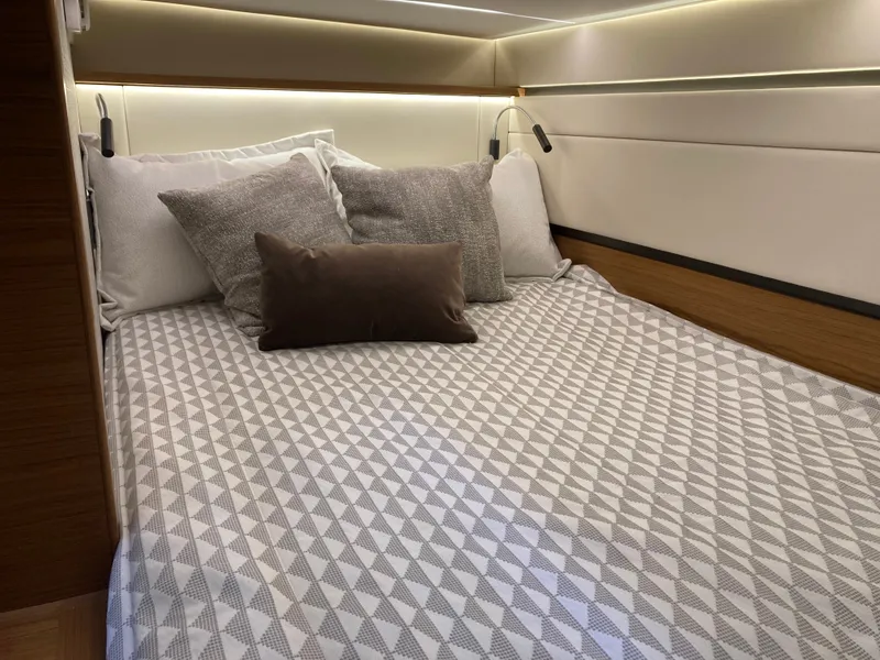 Slide: The Image of The 2027 Tiara Yachts 39LE cabin features a cozy bed with multiple pillows. - 30
