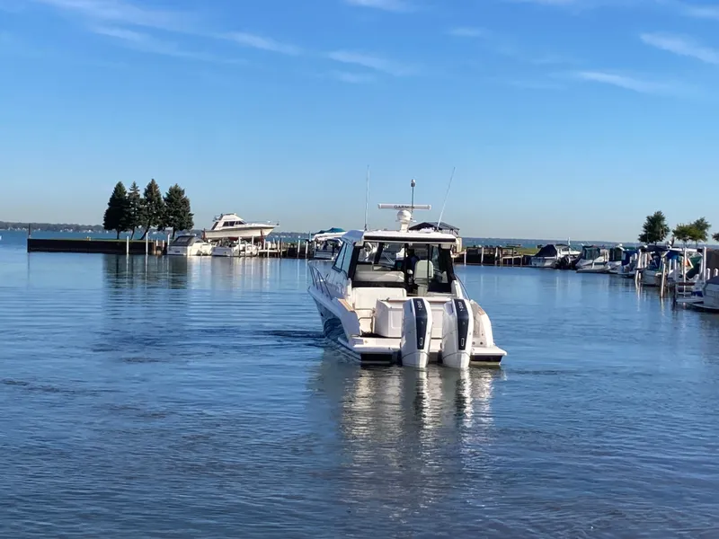 Slide: The Image of A 2027 Tiara Yachts 39LE departs a calm harbor under a clear sky. - 51
