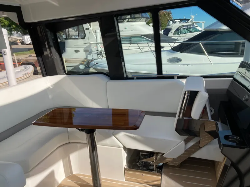 Slide: The Image of Interior of a 2027 Tiara Yachts 39LE with white upholstery and a wooden table. - 14