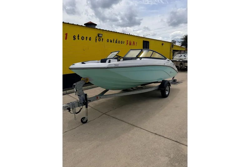 The Image of 2026 Yamaha Boats SX195 on trailer, parked outside a yellow building. - 1