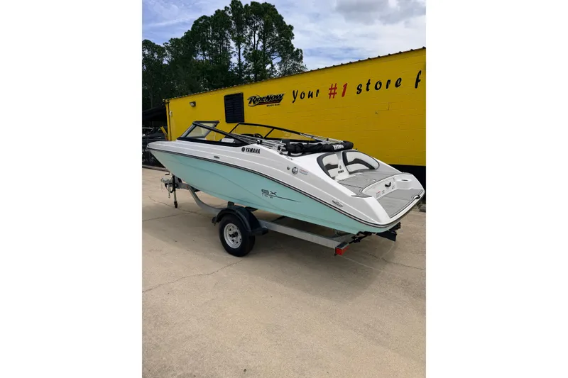 Slide: The Image of 2026 Yamaha Boats SX195 on trailer, parked outdoors near a yellow building. - 3