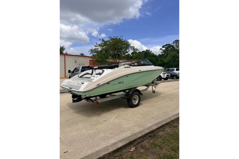 Slide: The Image of 2026 Yamaha Boats SX195 on trailer, parked outdoors under a cloudy sky. - 5