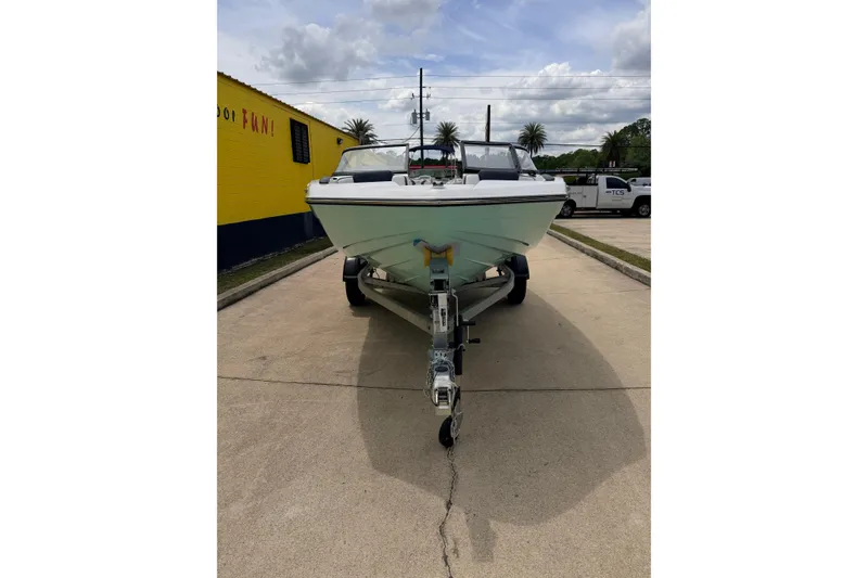 Slide: The Image of 2026 Yamaha Boats SX195 on trailer, parked outdoors under cloudy sky. - 7
