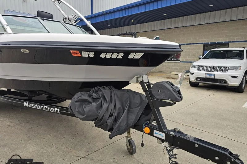 Slide: The Image of 2005 MasterCraft X-2 boat on trailer, parked beside a white SUV. - 11