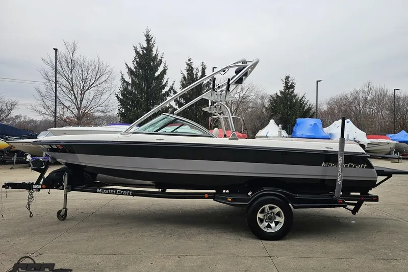 Slide: The Image of 2005 MasterCraft X-2 boat on trailer, parked outdoors, showcasing sleek design and modern features. - 18