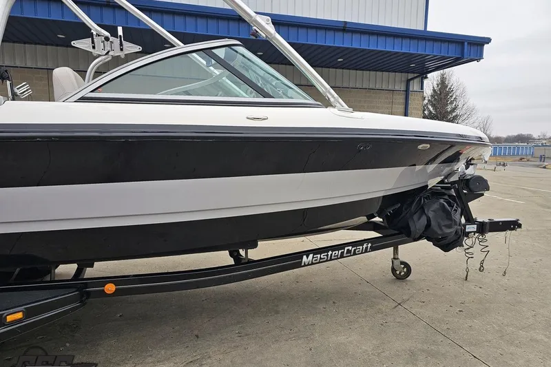 Slide: The Image of 2005 MasterCraft X-2 boat on trailer, parked outside a blue industrial building. - 3