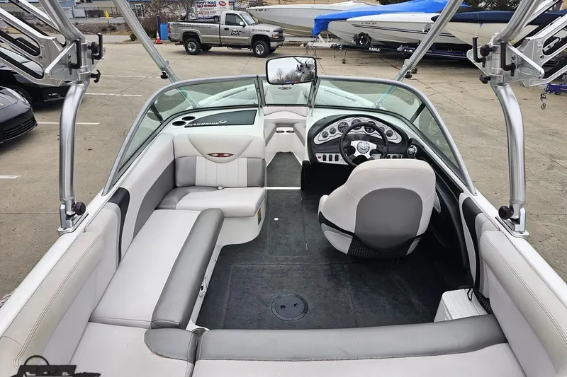 Slide: The Image of 2005 MasterCraft X-2 boat interior with seating and steering wheel, parked in a marina. - 34