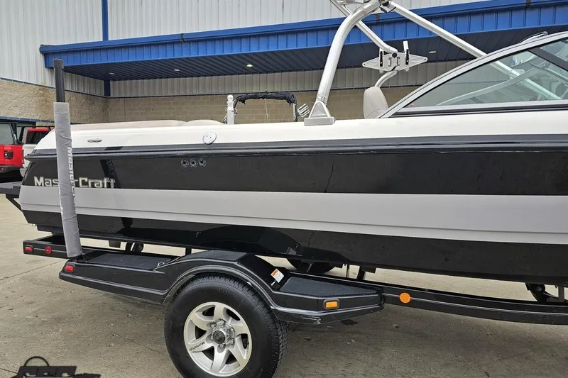 Slide: The Image of 2005 MasterCraft X-2 boat on trailer, black and white exterior, parked outdoors. - 4