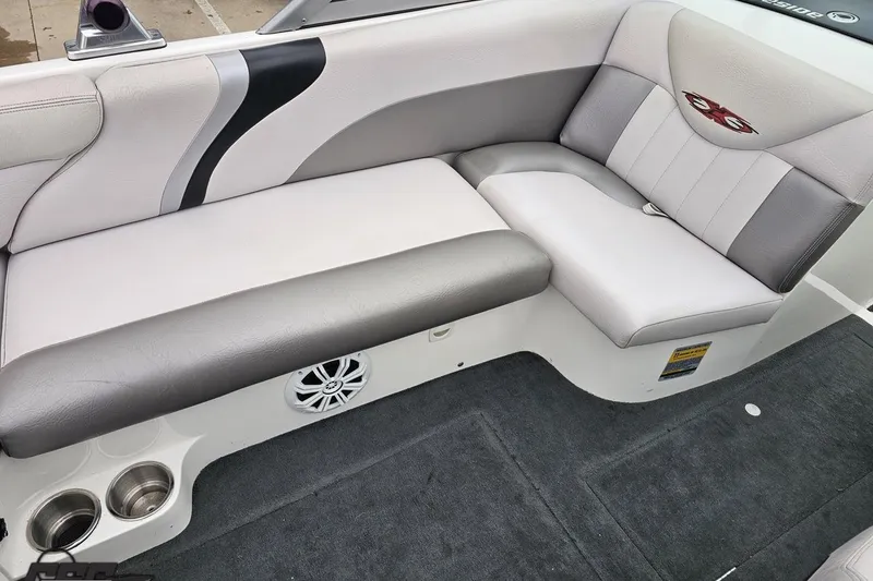 Slide: The Image of 2005 MasterCraft X-2 boat interior with gray and white seating, cup holders, and speaker. - 43