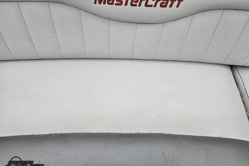 Slide: The Image of 2005 MasterCraft X-2 boat interior with white leather seating and red logo. - 76