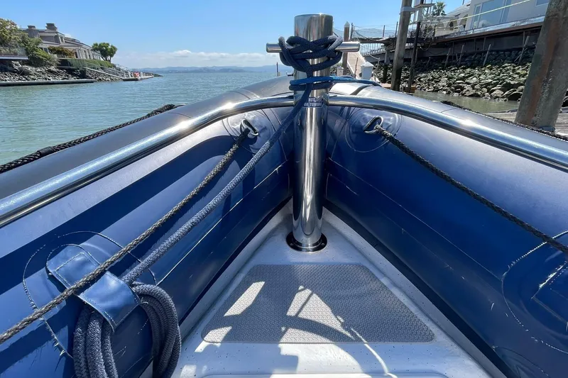 Slide: The Image of 2006 Protector Targa 28 boat bow with ropes and chrome post, docked by the water. - 20
