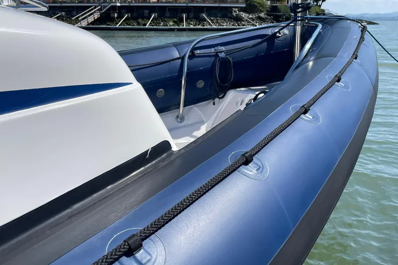 Slide: The Image of 2006 Protector Targa 28 boat with blue inflatable sides, docked near a waterfront. - 22