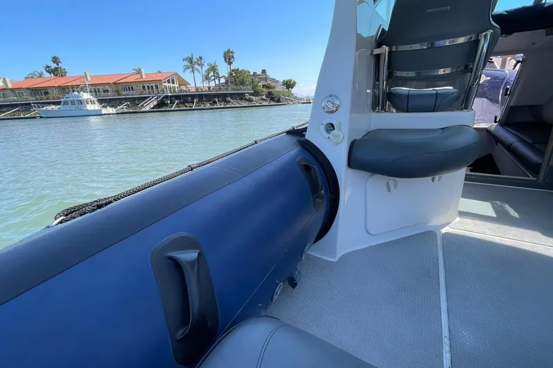 Slide: The Image of Interior view of a 2006 Protector Targa 28 boat with seating and waterfront backdrop. - 24