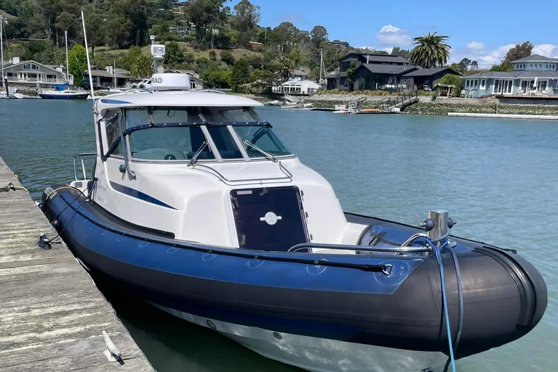 Slide: The Image of 2006 Protector Targa 28 boat docked by a scenic waterfront. - 26