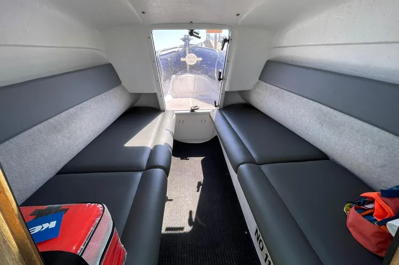Slide: The Image of Interior of a 2006 Protector Targa 28 boat with cushioned seating and storage. - 28