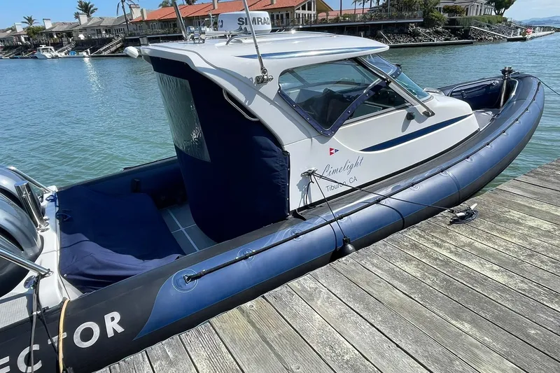 Slide: The Image of 2006 Protector Targa 28 boat docked by the water, featuring a sleek design. - 6