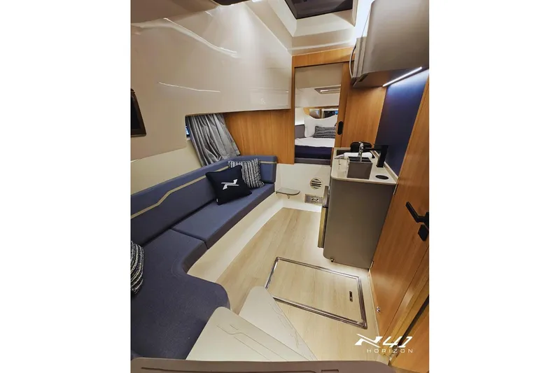 Slide: The Image of Interior of 2025 NX Boats NX41 HORIZON, featuring modern seating and compact kitchenette. - 10