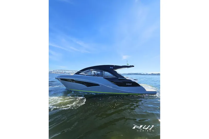 Slide: The Image of 2025 NX Boats NX41 HORIZON cruising on open water under clear blue skies. - 2