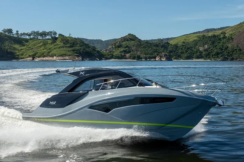 Slide: The Image of 2025 NX Boats NX41 HORIZON cruising on a scenic lake with lush green hills. - 20