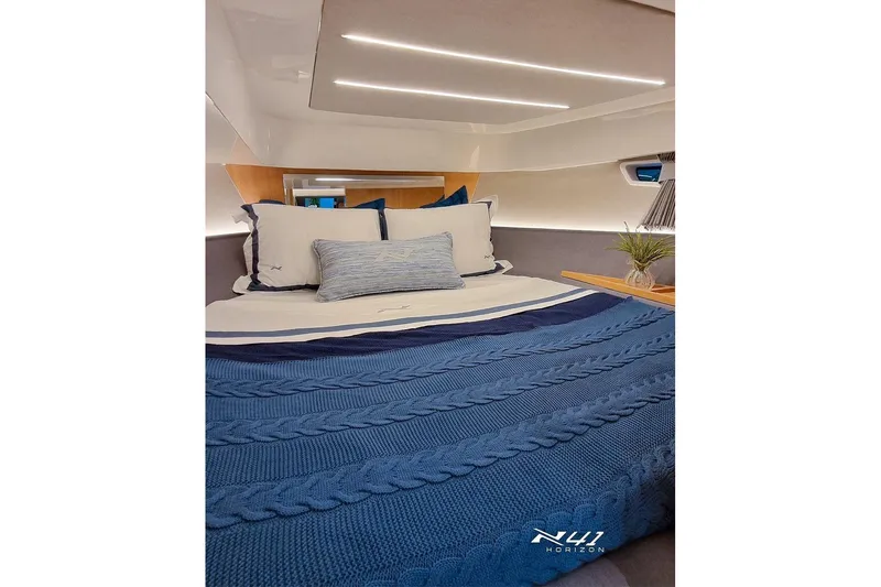 Slide: The Image of Luxurious cabin interior of 2025 NX Boats NX41 HORIZON with blue bedding. - 7