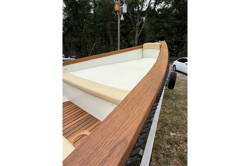 Slide: The Image of 2014 Sea Skiff Caribiana boat with wooden deck and beige seating, parked on a trailer. - 15