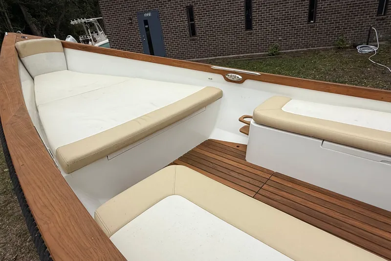 Slide: The Image of 2014 Sea Skiff Caribiana boat interior with cushioned seating and wooden accents. - 17