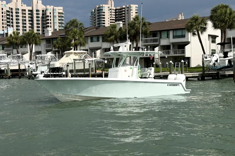 The Image of 2019 Contender 30 ST boat docked near waterfront buildings and palm trees. - 0
