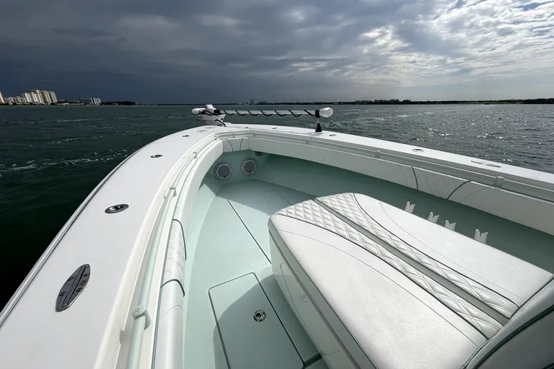 Slide: The Image of 2019 Contender 30 ST boat on water, featuring sleek white interior and overcast sky. - 11