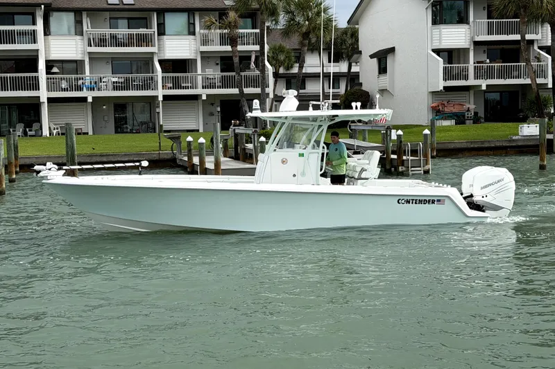 Slide: The Image of 2019 Contender 30 ST boat cruising near waterfront homes. - 2