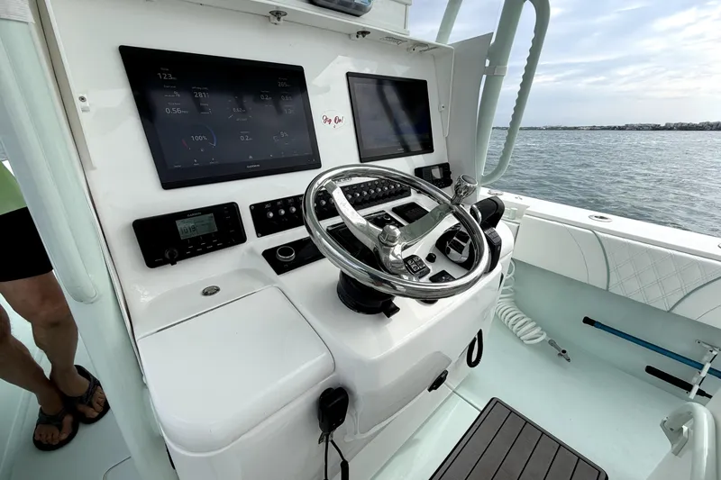 Slide: The Image of 2019 Contender 30 ST boat helm with modern navigation displays and steering wheel. - 23
