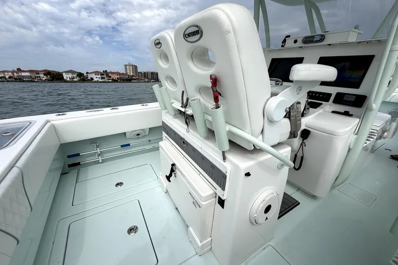 Slide: The Image of 2019 Contender 30 ST boat interior with helm station and seating, docked near waterfront homes. - 24