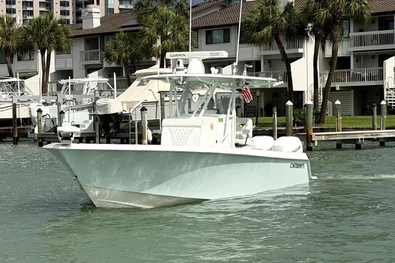 Slide: The Image of 2019 Contender 30 ST boat docked near waterfront homes with palm trees. - 3