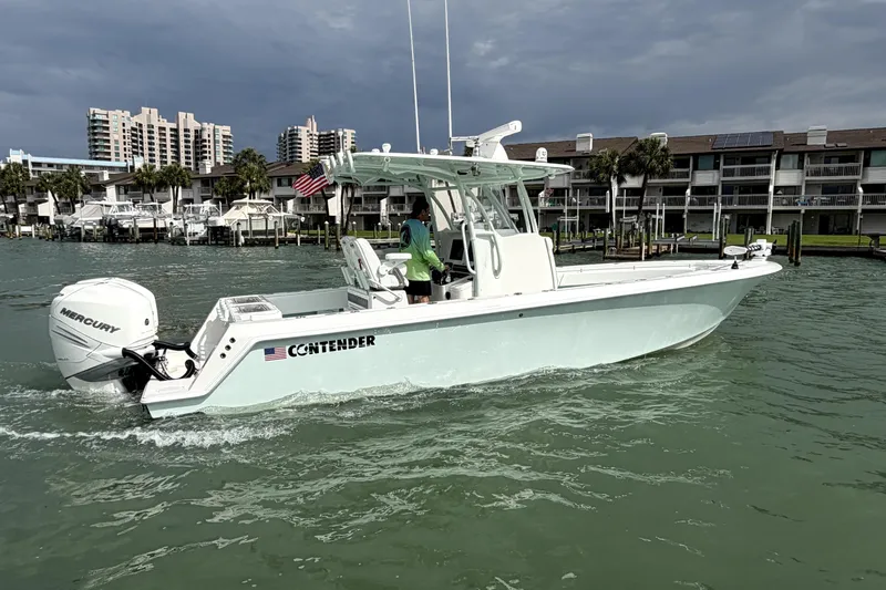 Slide: The Image of 2019 Contender 30 ST boat cruising in a marina with buildings in the background. - 5