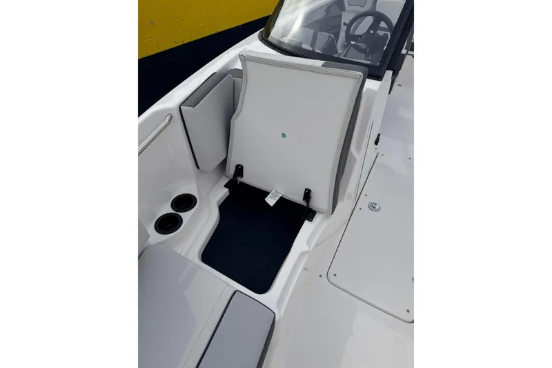 Slide: The Image of 2026 Yamaha Boats AR220 interior with open storage compartment and cup holders. - 14
