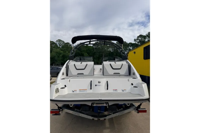 Slide: The Image of 2026 Yamaha Boats AR220, rear view, showcasing sleek design and spacious deck. - 2