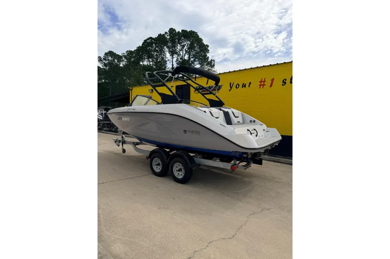 Slide: The Image of 2026 Yamaha Boats AR220 on trailer, parked outdoors near a yellow building. - 3